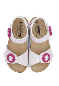 Sandales blanches avec des boucles en forme de fleur rose, fabriquées en matériau texturé. Elles possèdent deux sangles réglables et une semelle en liège. Taille 24.