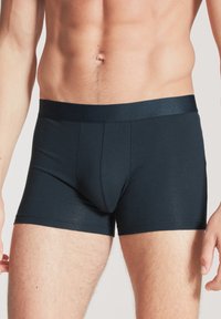 Donkerblauwe boxershorts gemaakt van zachte, rekbare stof. Heeft een gladde tailleband en een nauwsluitend ontwerp voor comfort en ondersteuning.