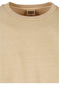 Sweatshirt bej cu guler rotund ribbed, realizat dintr-un material moale, având un etichetă de la "Urban Classics" în interiorul gulerului. Mărimea M.