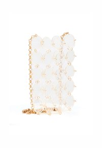 Transparente Acryl-Handtasche mit goldener Kette, ausgestattet mit ineinandergreifenden, kreisförmigen Formen; glatte Textur und offenes Design, auf einem weißen Hintergrund liegend.
