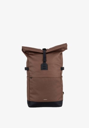 Brauner Rolltop-Rucksack mit schwarzem Schnallenverschluss und schwarzem Boden, aufrecht stehend vor weißem Hintergrund.