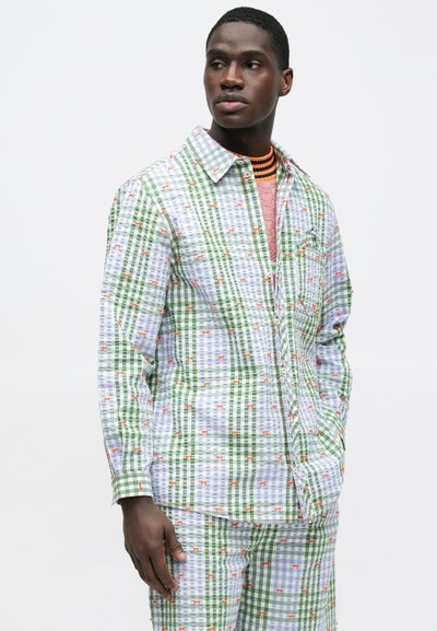 Πουκάμισο με πολλαπλά σχέδια σε πράσινο και μπλε καρό με πορτοκαλί λεπτομέρειες· διαθέτει γιακά, κουμπιά και μακριά μανίκια. Ομαλή υφή.