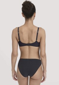 Zwarte beha en bijpassende slipset van gladde stof met verstelbare bandjes en een standaard sluiting achter. Minimalistisch ontwerp, zonder patronen.