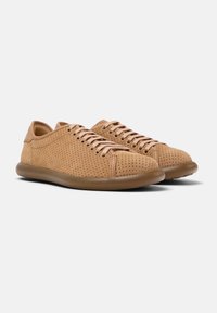 Zapatillas de cuero marrón con un diseño perforado, puntera redonda, suela de goma beige y cordones marrones. El detalle de costura lateral realza la estructura.