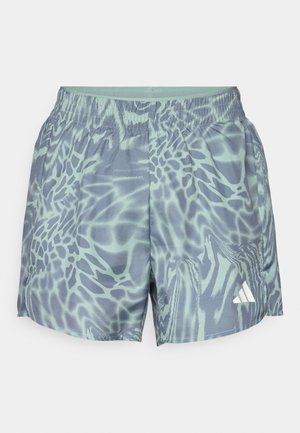Shorts de sport à motifs dans des tons de gris clair et de bleu. Taille élastique et poches latérales. Présente un logo Adidas en bas à droite.