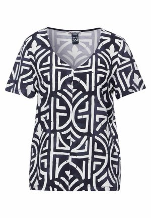 Haut à manches courtes et col en V, en bleu marine et blanc, présentant un motif géométrique avec des lignes et des formes audacieuses, fabriqué en tissu léger.