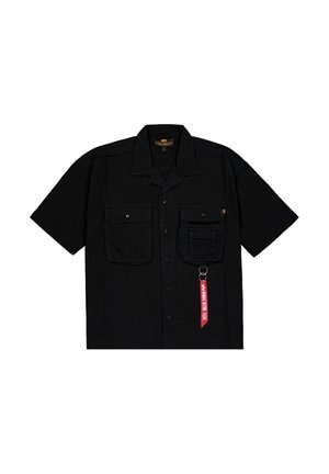 Chemise noire à manches courtes en tissu, dotée de deux poches avant, d'une fermeture à boutons et d'une étiquette rouge avec du texte et un clip en métal.