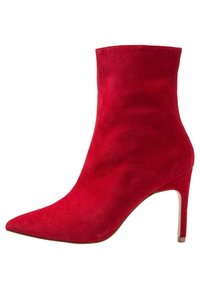 Czerwone zamszowe botki za kostkę z spiczastym noskiem i 10-centymetrowym obcasem w kształcie szpilki. Gładka tekstura i smukła sylwetka, w jednolitym kolorze bez ozdób.