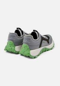Scarpe sportive grigie con suola verde e dettagli neri. Presentano una tomaia testurizzata, una suola ammortizzata e linguette di presa sul tallone.