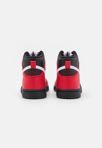 Röda och svarta högskurna sneakers med en slät läderfinish, kontrasterande vita detaljer, vadderad krage och texturerad gummisula.