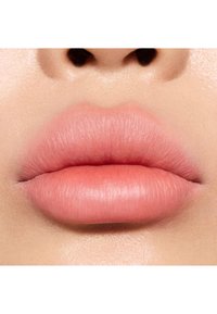 Gros plan sur des lèvres pleines et lisses d'une teinte rose doux, affichant une texture naturelle avec des contours bien définis et une finition mate.