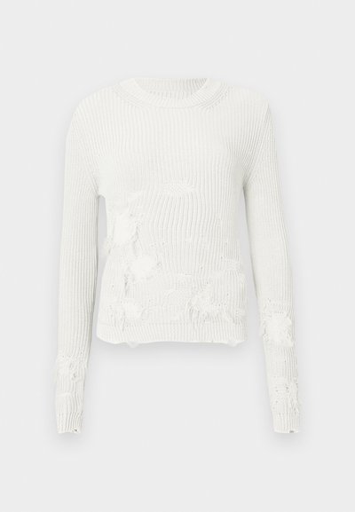 Pull blanc en tricot avec un col rond et des manches longues, présentant des zones usées et un design ample et texturé.