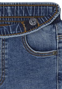 Jeansstoff in Dunkelblau mit kontrastierenden orangenen Nähten. Verfügt über einen Knopfverschluss und eine kleine Vordertasche. Strukturiert Oberfläche.