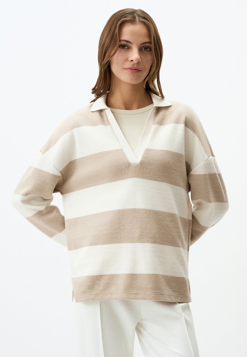 Pullover a righe beige e bianche con scollatura a V e colletto, realizzato in un tessuto morbido. Presenta una vestibilità rilassata e spacchi laterali sull'orlo.
