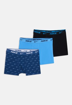 Trois paires de boxers Nike bleu marine avec motif logo, bleu clair uni et noir uni, disposées sur un fond blanc uni.