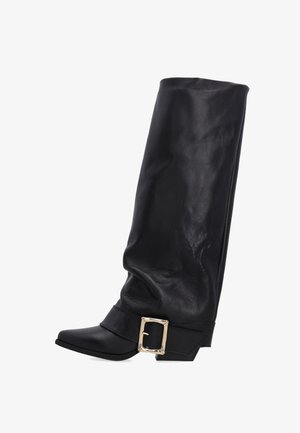 Schwarze, knöchelhohe Stiefel aus Leder mit einem lässigen Design, spitzem Fuß und einem goldenen Schnallenakzent am Fußbereich. Texturierte Oberfläche rundum.