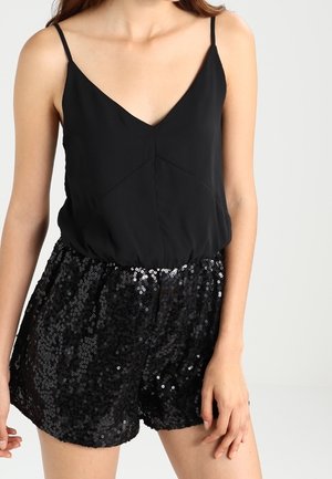 Schwarzes ärmelloses Oberteil mit V-Ausschnitt und geraffter Taille, kombiniert mit hoch taillierten Shorts, die mit schwarzen Pailletten bedeckt sind.