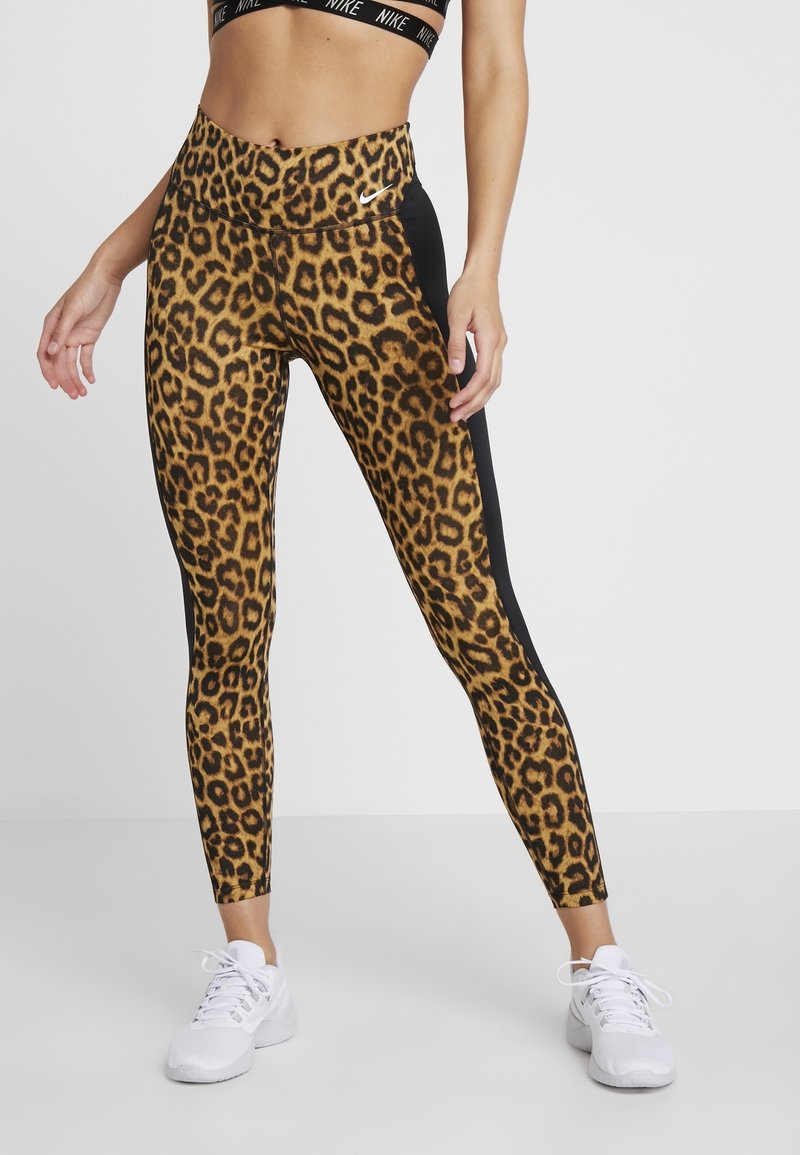 Luipaardprint leggings met een hoge tailleband en zwarte zijpanelen. Zacht, rekbaar materiaal voor comfort en beweging. Witte sportschoenen.