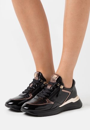 Sneaker neri e bronzo in pelle lucida e testurizzata, con chiusura a zip e suola spessa. Accentuati da dettagli in metallo dorato.
