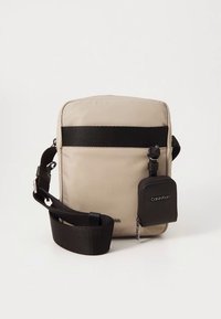 Beige crossbody bag with a large main compartment, black strap, and small detachable pouch. Smooth fabric with a minimalist design.