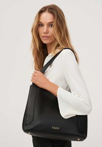 Fekete bőr kézitáska texturált felülettel, arany logóval és egy vállpánttal. Strukturált forma és tágas belső tér.