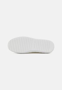 Semelle de sneaker blanche avec un grip texturé, présentant un motif strié et un nom de marque en relief. Matériau lisse avec une composition en caoutchouc durable.