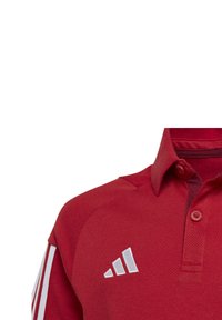 Rotes Polohemd aus strukturiertem Stoff, mit einem geknöpften Kragen und einem weißen gestickten Drei-Streifen-Logo auf der linken Brust.
