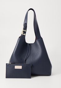 Navy leather handbag with a textured finish, large hobo shape, gold-toned hardware accent, and a small detachable zip pouch attached.