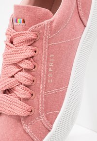 Baskets Esprit roses avec des lacets tissés épais, une étiquette en tissu arc-en-ciel, une semelle blanche texturée et des détails de couture visibles.