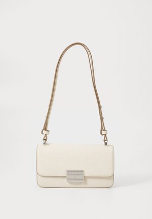 Bolso de cuero crema con forma estructurada, cierre plateado y una correa larga y ajustable en tono marrón. Textura suave con un grano sutil.