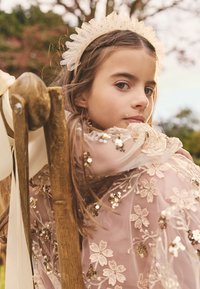 Hele roosa kleit lilleline tikand ja litrid, läbipaistva pealmise kihiga. Kullast peapael volangiliste äärtega. Puittool nähtav.