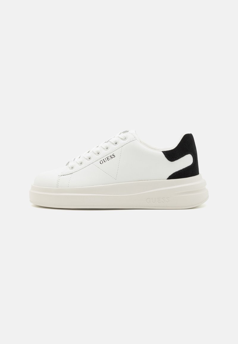 Baskets en cuir blanc avec une épaisse semelle blanche, un accent en daim noir au niveau du talon et un logo embossé sur le côté. Design à lacets avec six œillets.