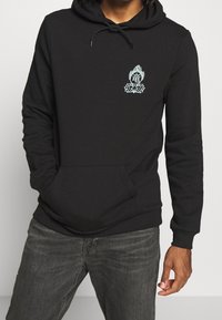 Czarna bluza z kapturem, posiadająca kieszeń z przodu, z turkusowym wzorem graficznym na klatce piersiowej, wykonana z miękkiego materiału, z regulowanym kapturem.