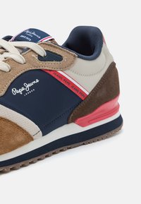 Pepe Jeans athletic shoe featuring a mix of brown suede, navy synthetic, and light gray accents. It has a thick navy sole and branded details.