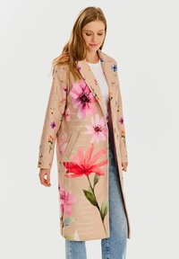 Svetlo béžový kvetinový kabát s ružovými a fialovými kvetinovými vzormi. Má dlhý strih, klopový golier a dve bočné vrecká. Ideálny na jar.