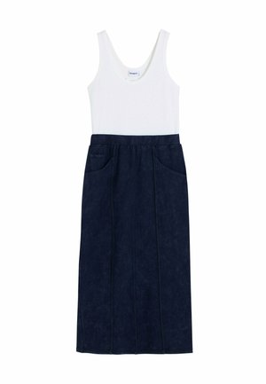 Top bianco senza maniche abbinato a una gonna midi scura di colore blu navy a vita alta, con tasche frontali e dettagli delle cuciture verticali.