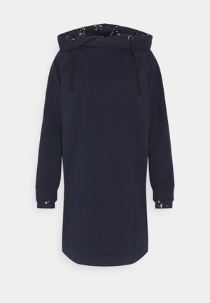 Robe à capuche longue bleu marine avec une grande capuche dotée de cordons noirs et une doublure en tissu à taches multicolores visible à l'intérieur de la capuche et des poignets.