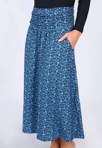 Lange Rock mit blauem Blumenmuster, einem gerafften, elastischen Bund und seitlichen Taschen. Hergestellt aus leichtem, weichem Stoff mit einer glatten Textur.