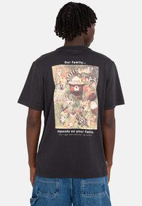 Black cotton t-shirt featuring a colorful graphic of various animals and text on the back, highlighting a wildlife prevention theme.