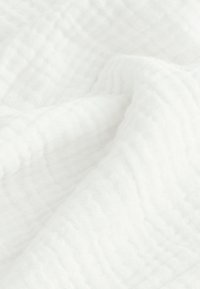 Tessuto bianco, texturizzato, con un motivo rugoso, leggero e arioso, che riflette una morbida e sottile lucentezza. Ideale per diverse applicazioni.