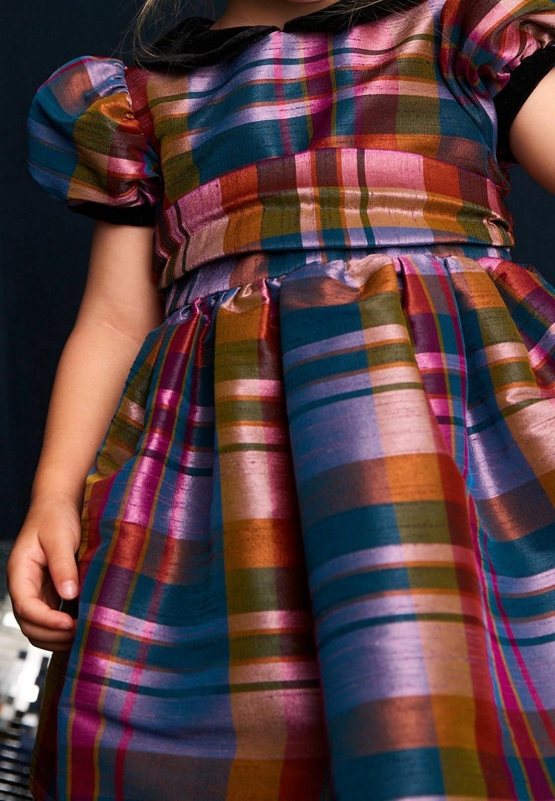 Färgglad rutig klänning med puffärmar, med metallisk lyster i nyanser av rosa, blått, grönt och guld. Fårad kjol med texturerad tyg.