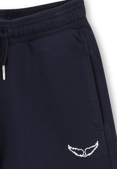 Pantalon de survêtement bleu marine avec taille élastique, cordon, poche latérale et petit logo brodé blanc en forme d'aile près de la poche.