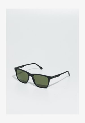 Square sunglasses with a matte black frame, green lenses, and a small green accent on the temples. Lightweight design with slim arms.