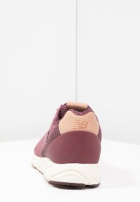Fialová a růžová sportovní bota z prodyšného a syntetického materiálu, zaoblený podpatek, texturované akcenty a logo na zadní straně.