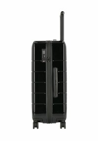 Black hard-shell suitcase with a matte texture, vertical grooves, side handle, retractable wheel handle, and four wheels for mobility.