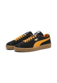 Sneaker Puma Delphin neri e arancioni con suole in gomma, lacci arancioni e marchio sul lato e sulla linguetta.