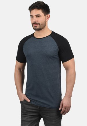 T-Shirt aus Baumwollmischung mit dunkelblauem Körper und schwarzen Raglanärmeln. Rundhalsausschnitt, kurze Ärmel und minimalistische Nähdetails.