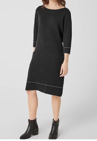 Tmavě šedé svetr šaty s lodí výstřihem, tříčtvrtečními rukávy, dvěma předními kapsami a kontrastním bílým lemováním.