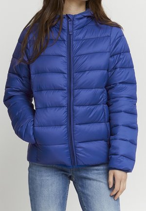 Blå puffy-jacka med horisontella kviltade sektioner, framzipper och huva. Tillverkad av lätt, glänsande material.