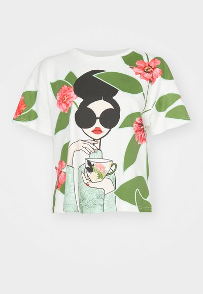 Hvid kortærmet t-shirt med en kvinde med sort hår iført solbriller, som holder en blomsterkop, dekoreret med grønne blade og pink blomster.
